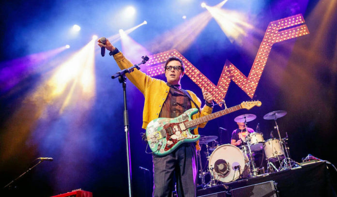 Weezer lead singer Rivers Cuomo performs in front of a crowd