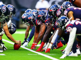 Players from the Houston Texans and Tennessee Titans line up for the snap of the ball.
