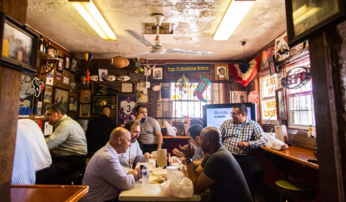 A small dining area in a smokehouse with photos and memorabilia covering the walls