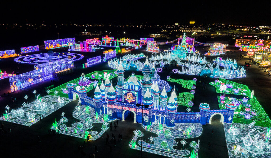 Colorful, bright structures covered in lights cover a field