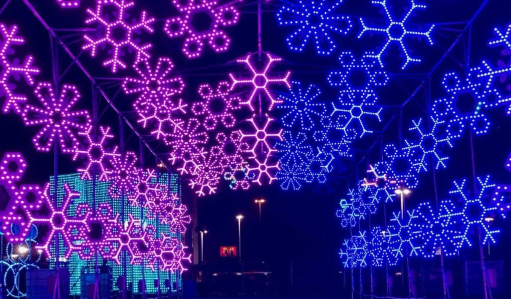 A drive through tunnel with pink and blue snowflake decorations