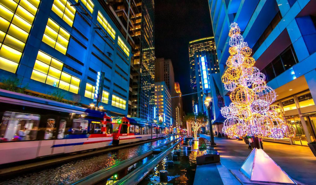 A downtown scene with Christmas decor and a lightrail train passing through