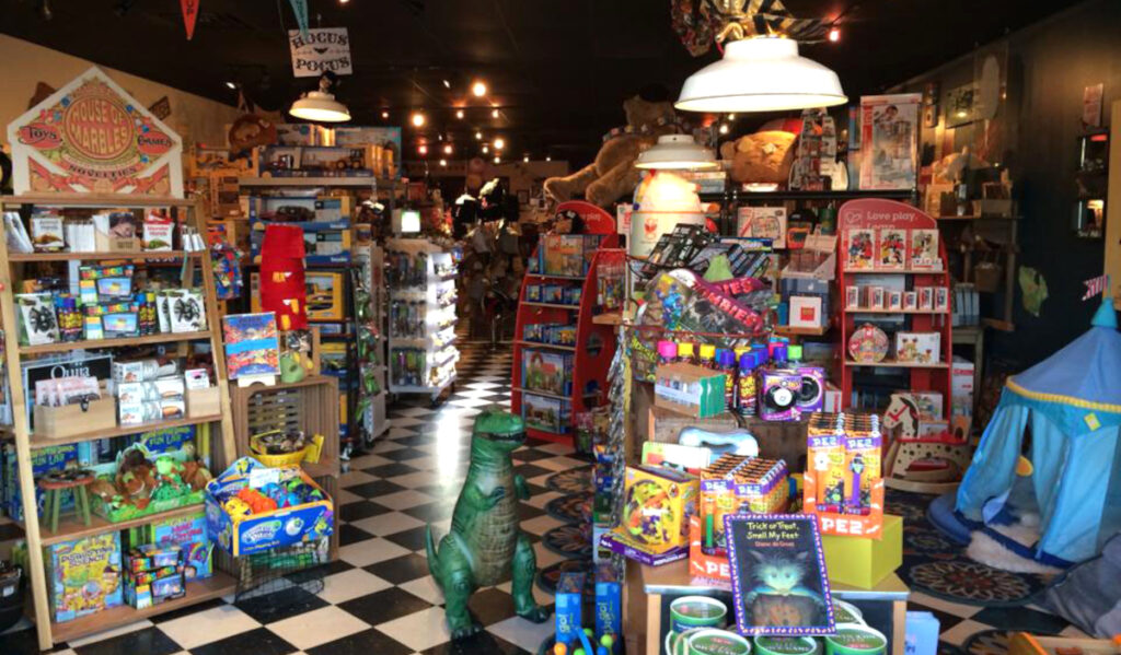 A toy store aisle with assorted books, games, stuffed animals and other toys
