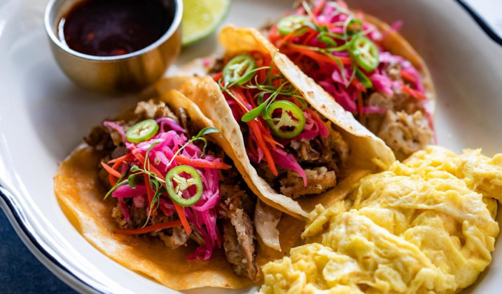 A plate of tacos with pickled garnishes