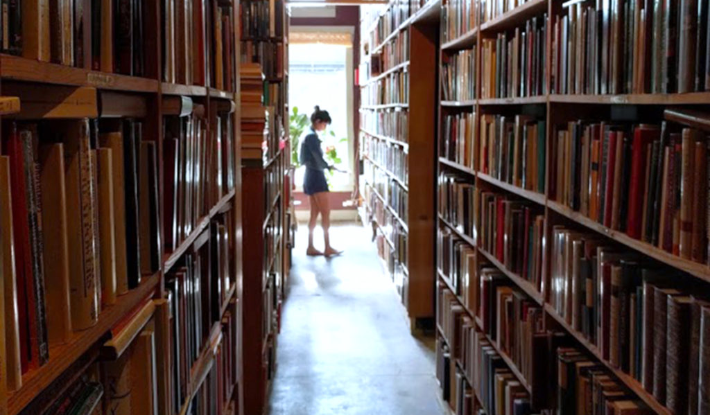 A customer browses tall bookshelves full of books