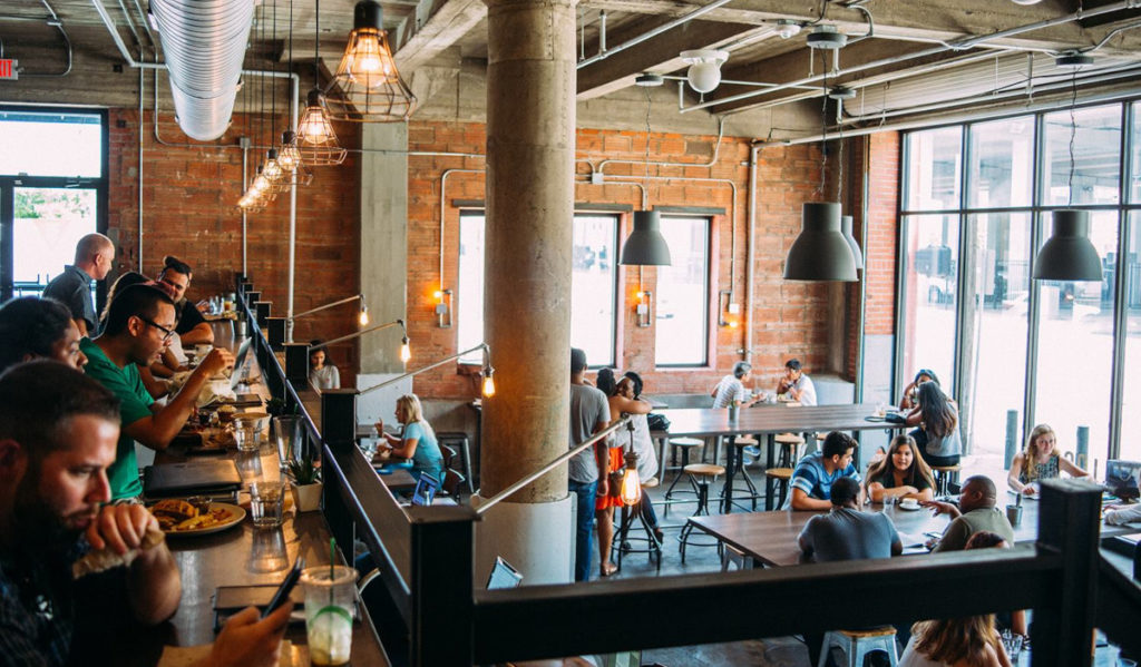 A crowded coffee shop with a brightly lit interior