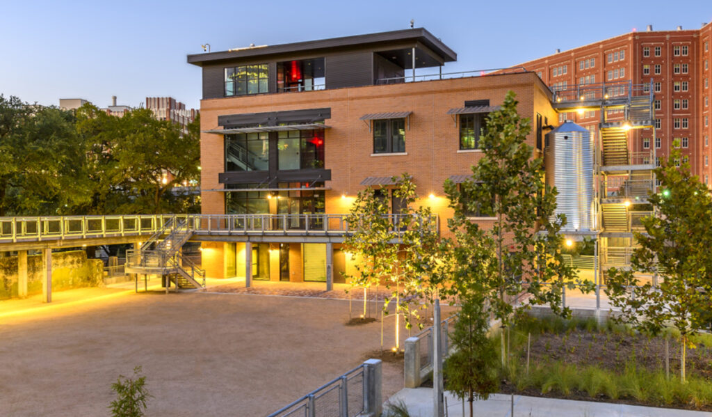 An evening view of a three-story building and landscaping