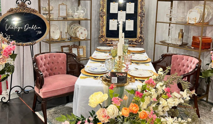 A vendor display of decorated tables, dinnerware, flowers and more for a wedding
