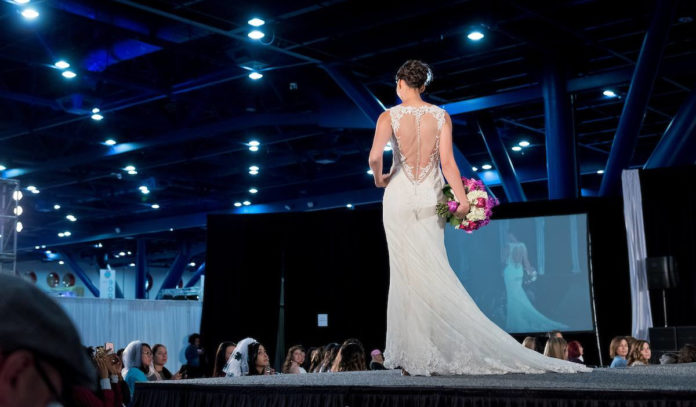 A fashion model showcases a wedding dress on the runway