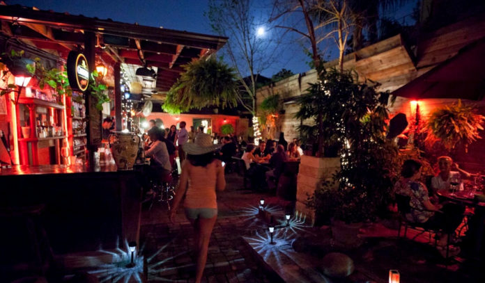 Nighttime on a bar's outdoor patio with people scattered around