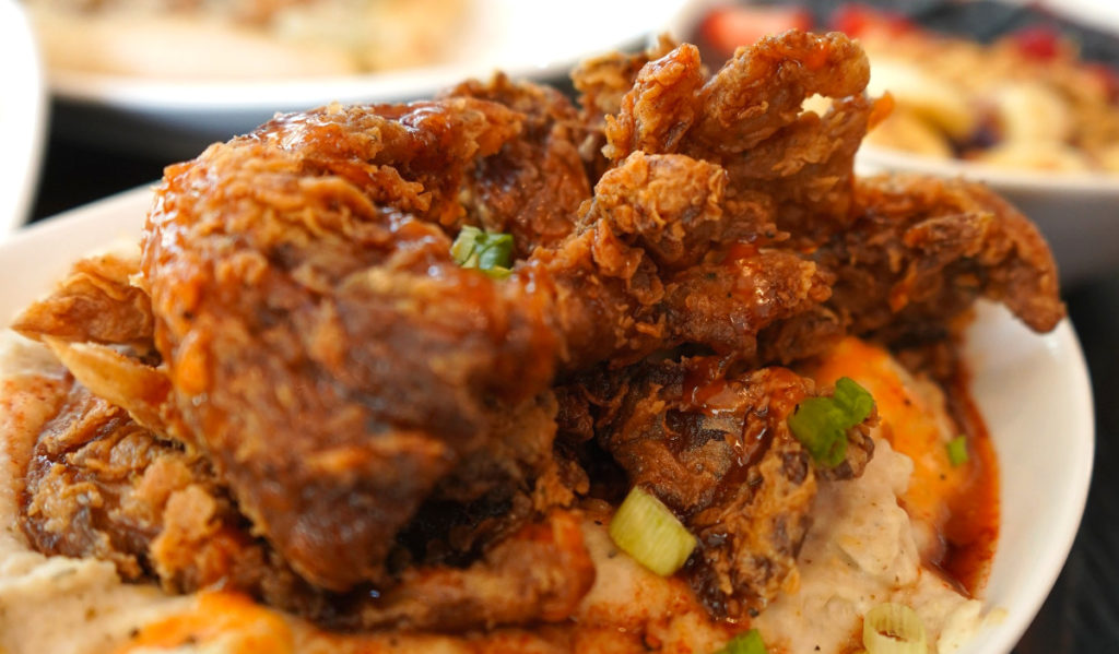 A close-up of fried mushrooms on a bed of grits