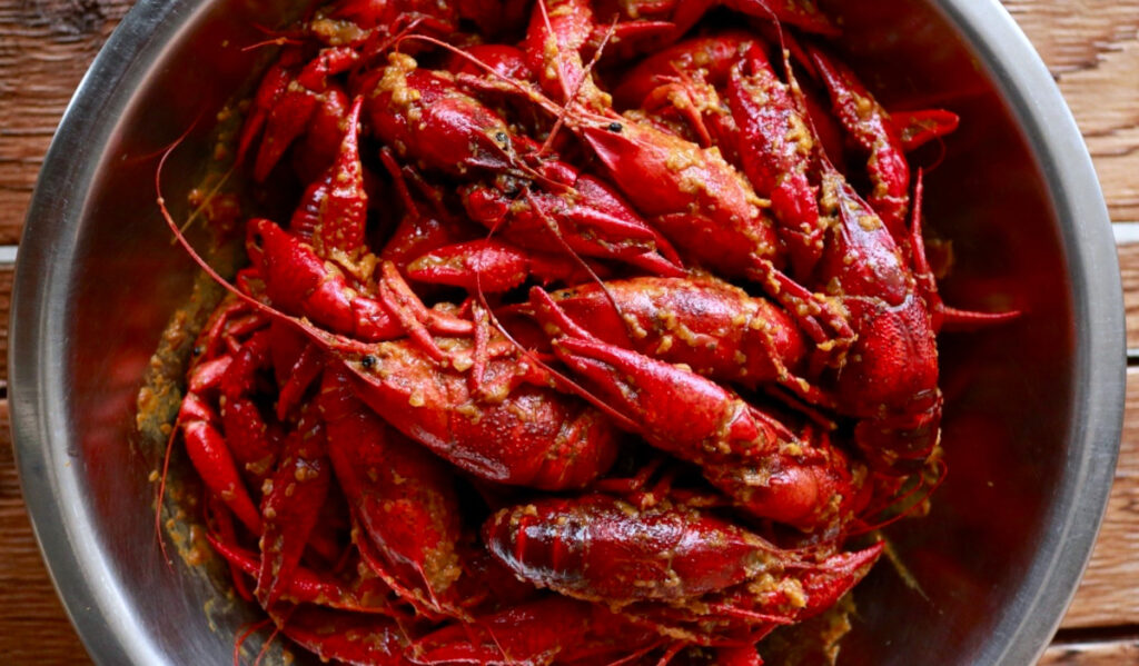 An ovehead view of crawfish with seasoning in a bowl