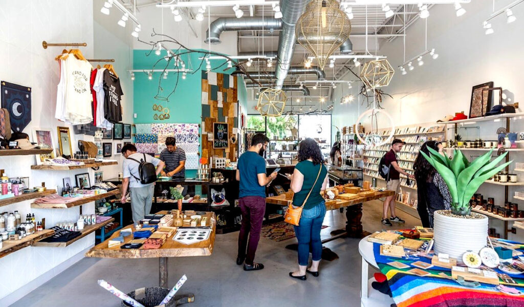 A bright shop filled with shoppers, clothing, decor and jewelry