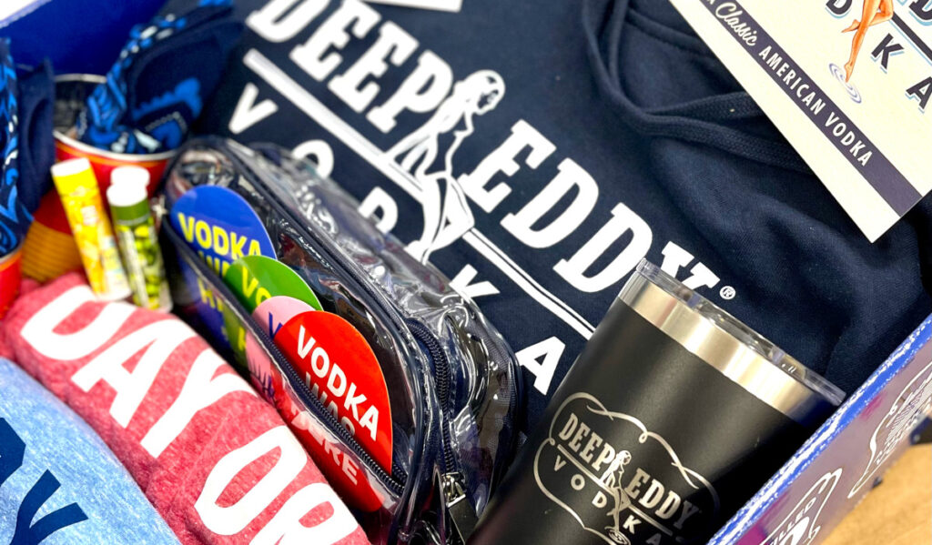 A close up of Deep Eddy Vodka-branded clothing, cups, stickers and more