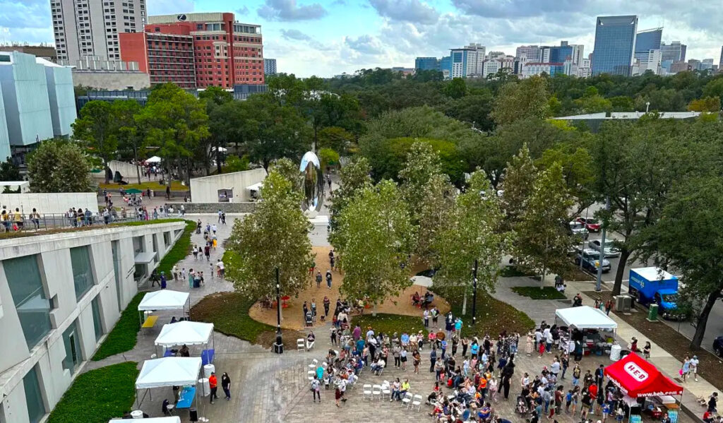 An aerial photo of an outdoor festival with people watching performances and walking around the grounds of MFAH