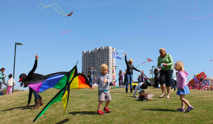 A child tries to get his kite in the air as others around him fly theirs