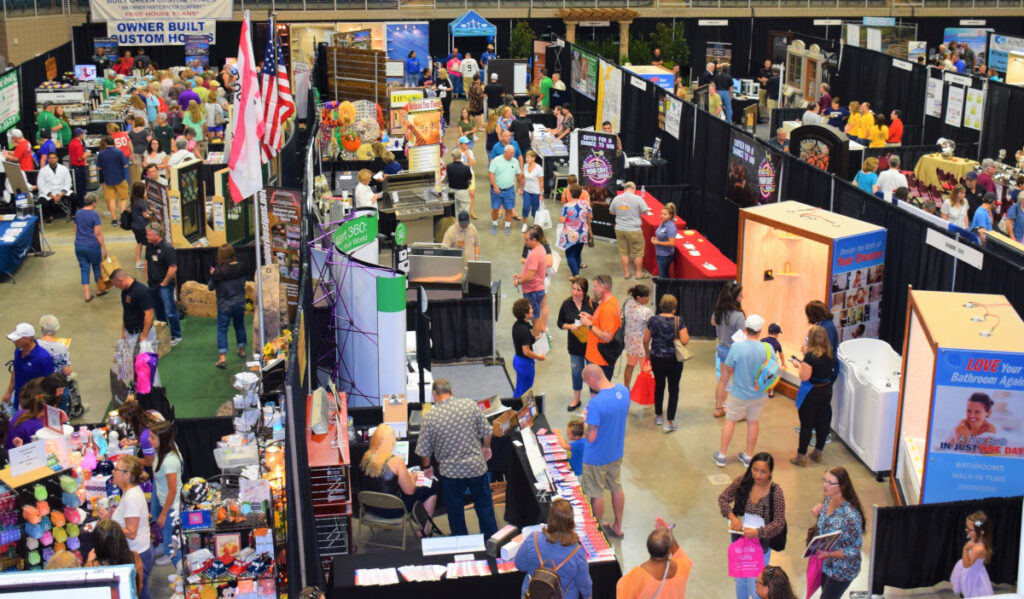 A convention floor with visitors browsing booths of vendor goods