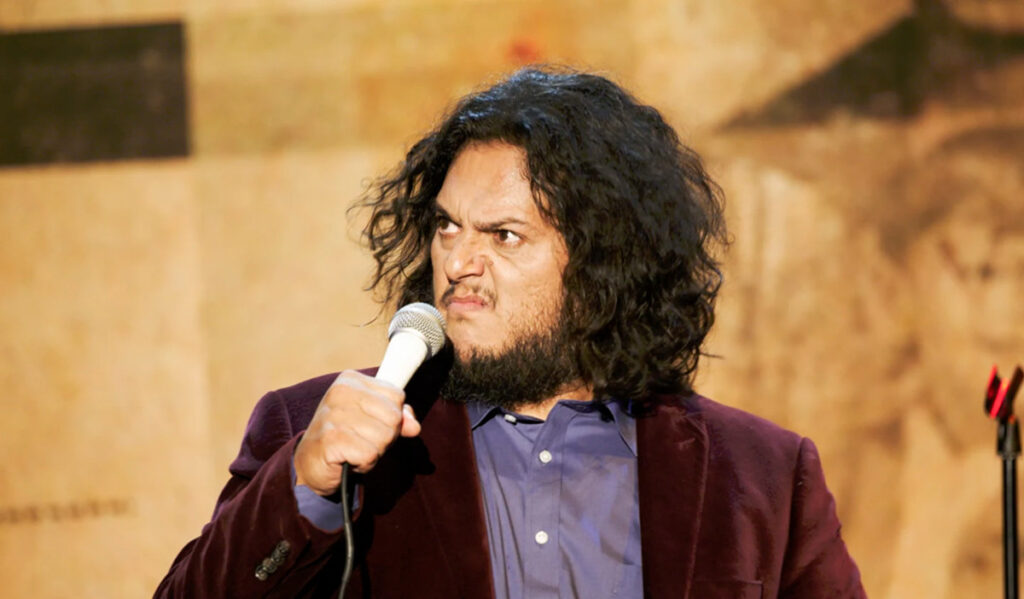 Comedian Felipe Esparza makes a bunched-up face while performing