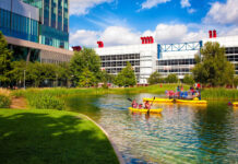 5 Must Do Things in Downtown Houston People kayak on water with a skyscraper and convention center in the background