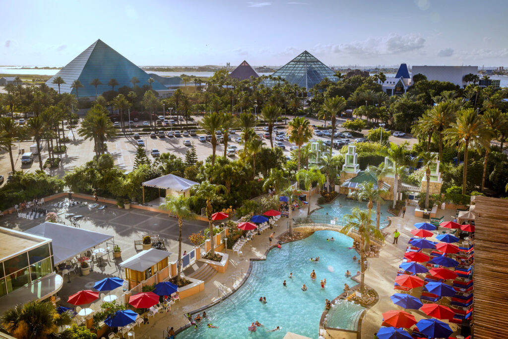 An aerial view of Moody Gardens with a swimming pool in the foreground and three pyramids in the background