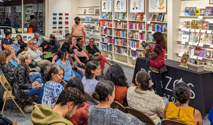 An in-store reading with people in rows of seating around an author