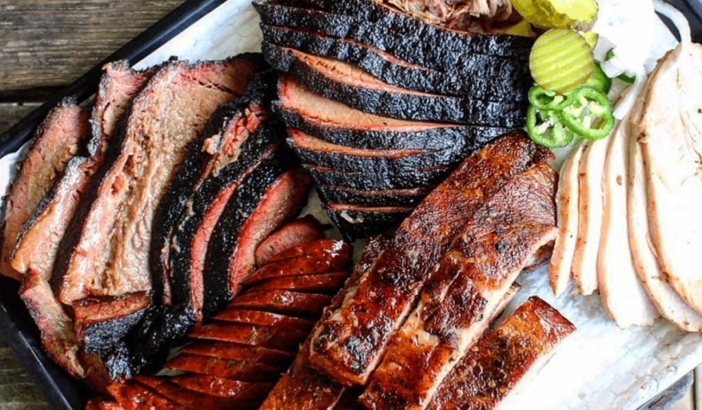 A plate of barbecue brisket, ribs and sausage