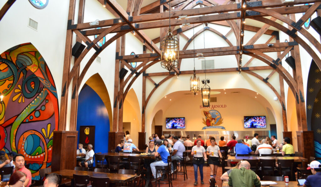 The arched interior of Saint Arnold Brewing Company with patrons seated and conversing