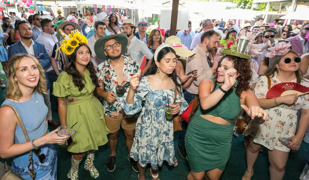 Onlookers watch the Kentucky Derby on an outdoor screen