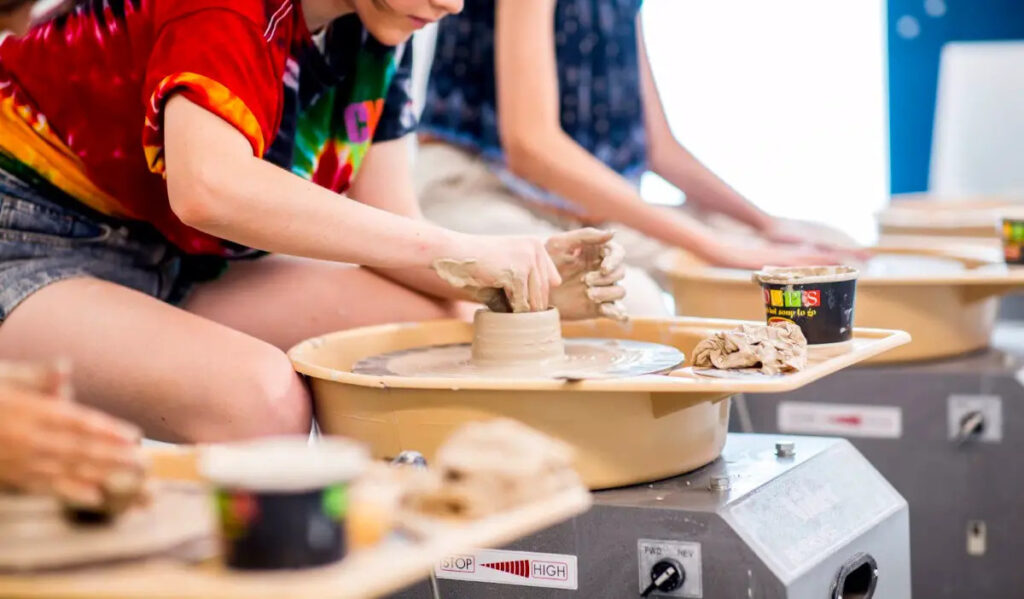 Children mold clay in a pottery class