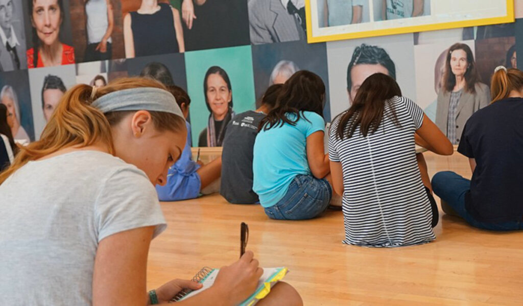 A group of teenagers participate in a writing exercise