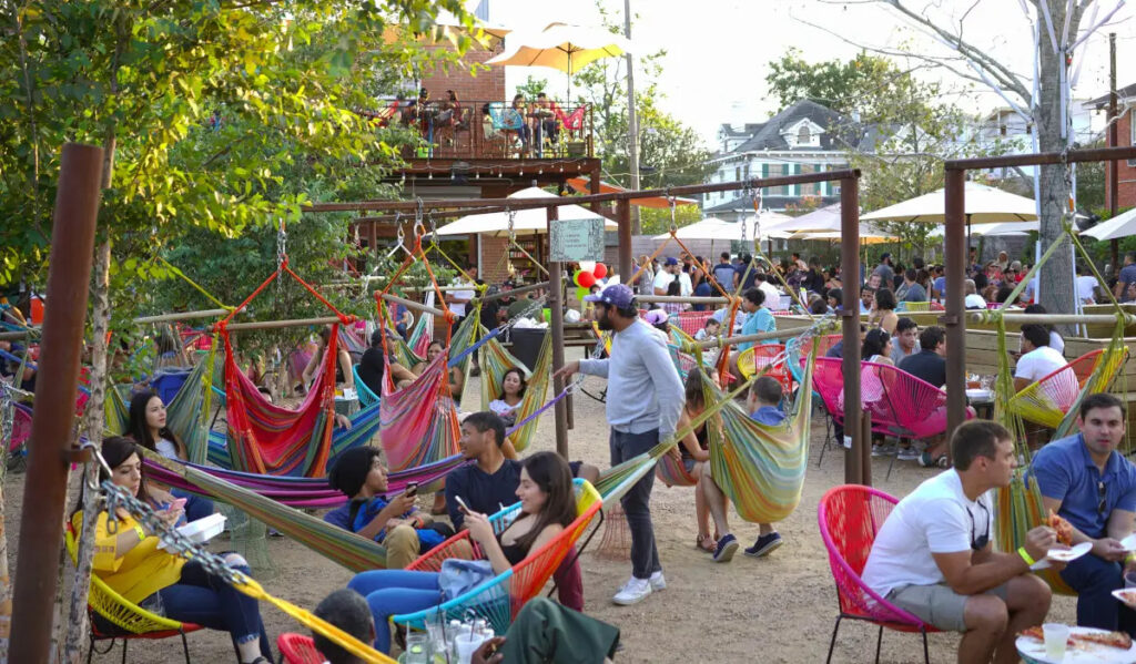 A spacious outdoor patio with people in hammocks and at tables