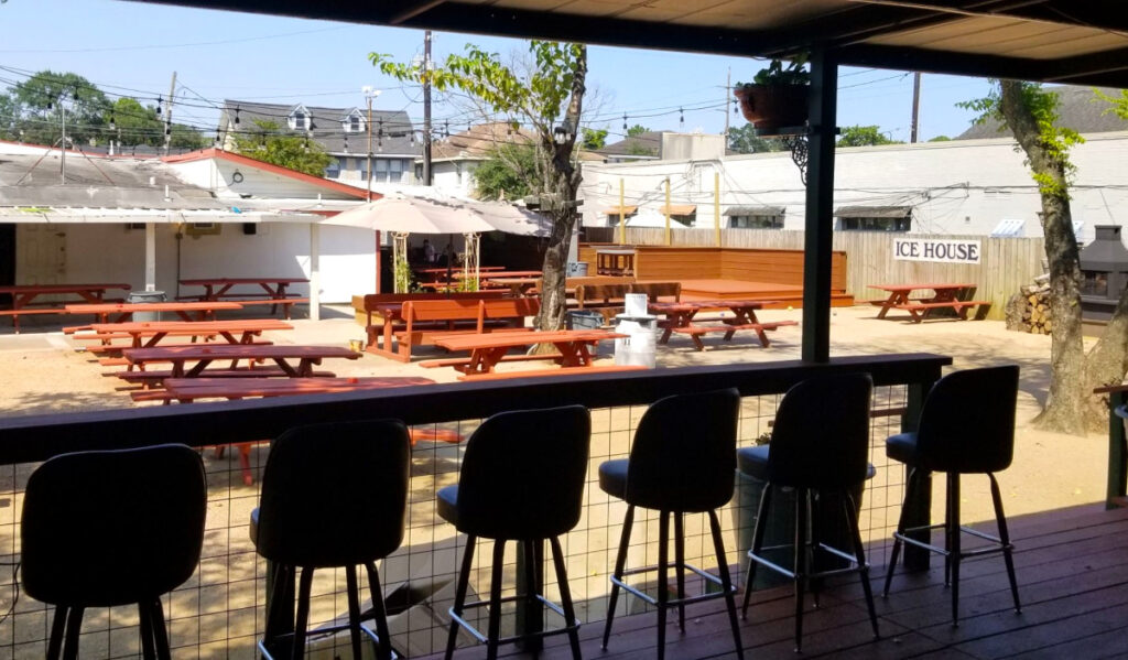 A view into a backyard patio from underneath a shaded canopy