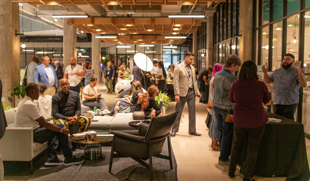 People gathered in small groups and pairs chat with one another at Houston's Ion building