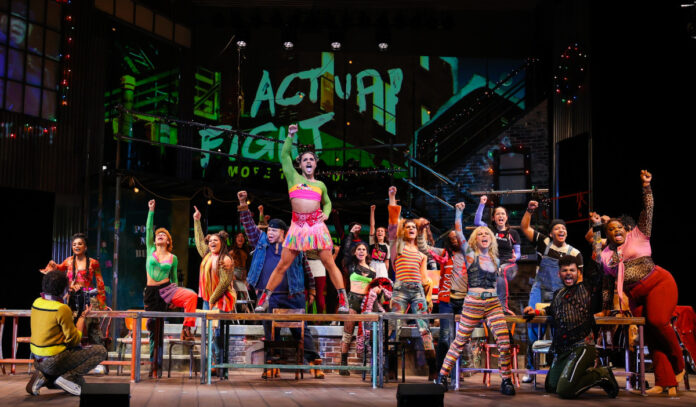 The ensemble from "Rent" performs, raising fists into the air