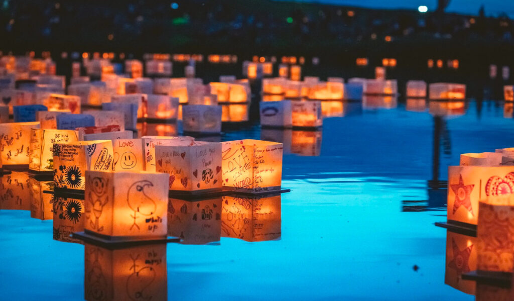 Dozens of decorated water lanterns drift on the water