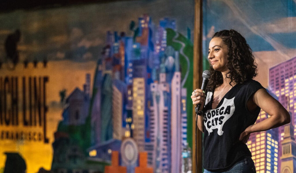 Comedian Liz Miele performs on stage