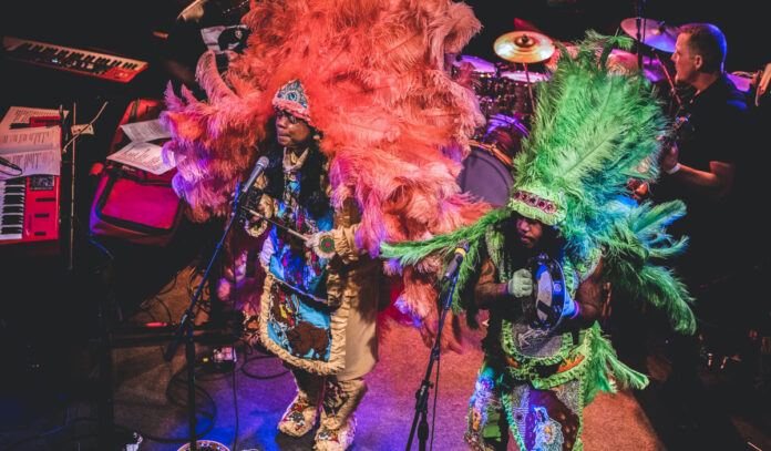 Two musicians of Cha Wa perform while in vibrant, feathery Native American dress