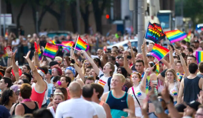 Revelers at the Pride Parade wave flags and celebrate