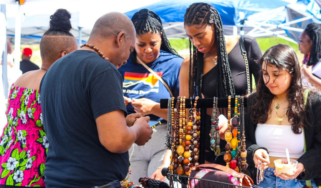 People peruse over goods at a pop-up vendor's booth