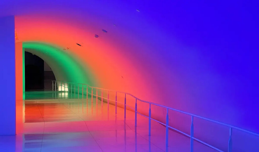 A tunnel at MFAH bathed in blue, orange and green light