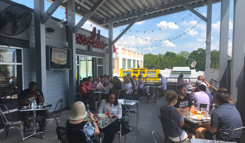 A covered outdoor patio filled with patrons eating