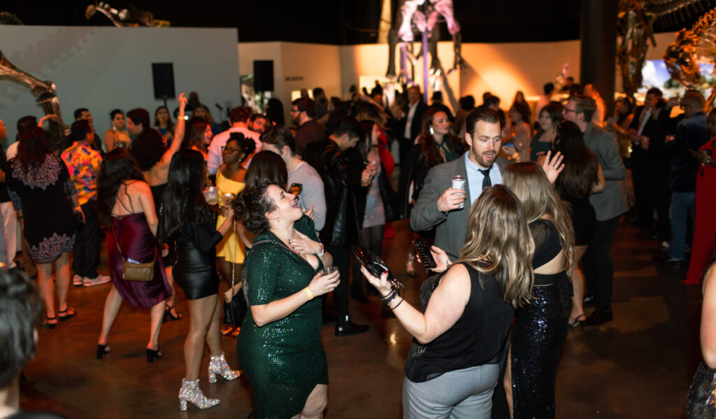 Party goers dance and converse in the Paleontology wing of HMNS