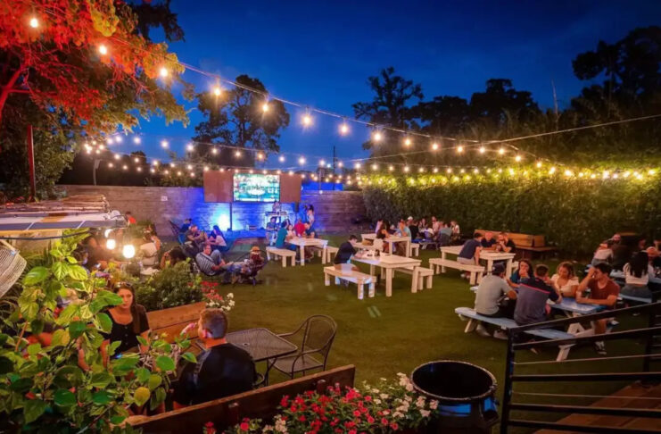 An outdoor patio space at night with a string of lights overhead