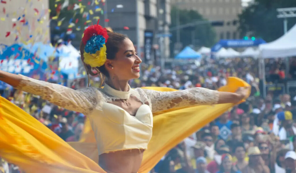 A performer dances while wearing the colors of the Colombian flag