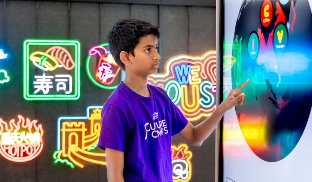 A child uses a touch screen at the 'Explore Asia' exhibition