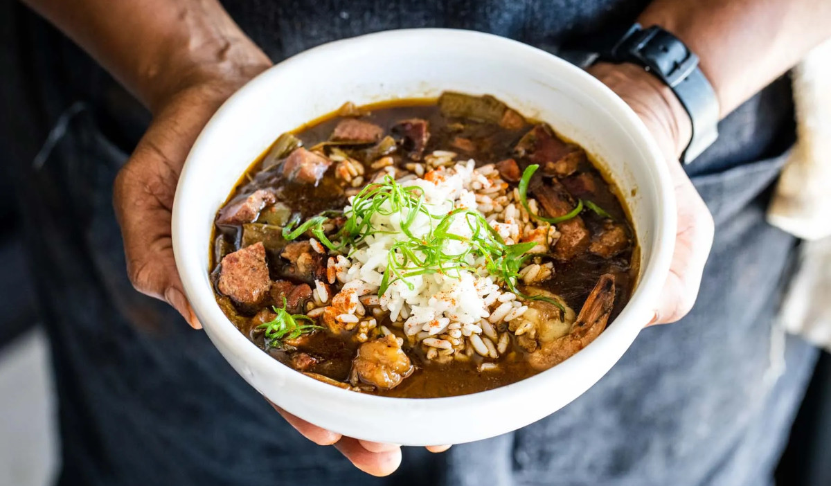 Hands holding a bowl of gumbo