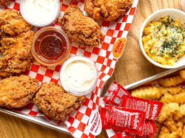 A tray of fried chicken wings with sides and fries