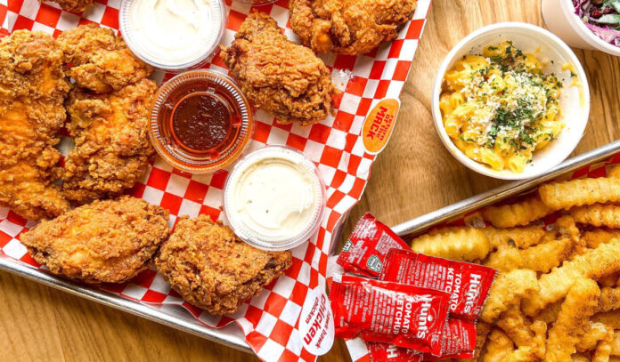 A tray of fried chicken wings with sides and fries