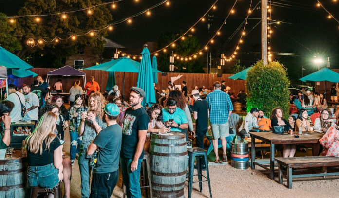 Groups of people talking in the outdoor patio of Social Beer Garden at night