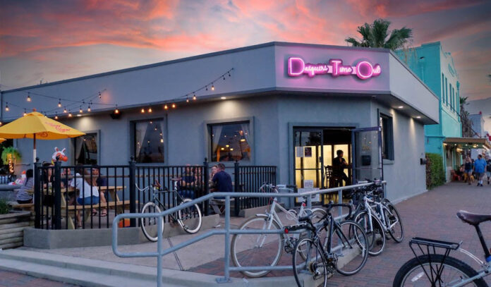 Exterior of Daiquiri Time Out at sunset with people on the patio